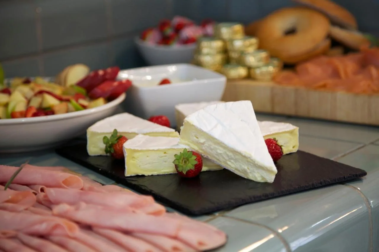 a plate of cheese and strawberries on a table at The Z Hotel Piccadilly in London